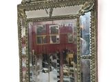 a mirror hanging on the wall with a building in the background