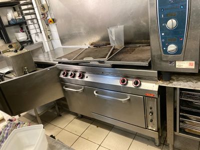 a large commercial kitchen with a lot of stainless steel appliances