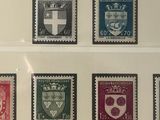 a lot of stamps that are on display in a glass case
