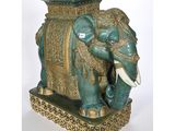 statue of an elephant with tusks on a base