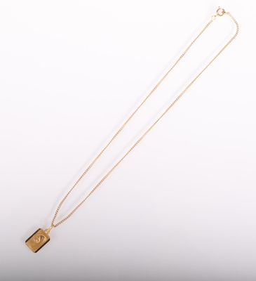 un collier plaqué or avec un pendentif de forme carrée monté sur une chaîne