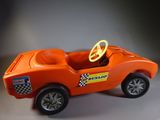 an orange toy car with a steering wheel and a checkered flag