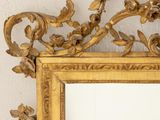 a gold framed mirror on the wall in a room