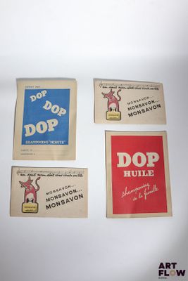 quatre autocollants publicitaires vintage représentant des boissons de différentes saveurs, posés sur une surface blanche