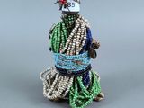 figurine en perles représentant une femme vêtue d'une robe verte et d'un chapeau