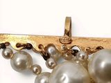 a close up of a brooch with pearls on it
