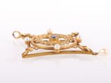 a close up of a gold broochle with pearls on it