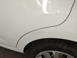 a close up of a white car with a denting on the side of it