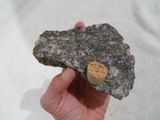 a person holding a piece of rock with a cork in it