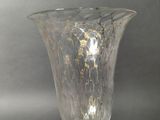 a glass vase that is sitting on a metal stand