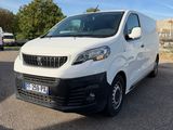 la camionnette blanche est garée dans un parking près d'un bâtiment