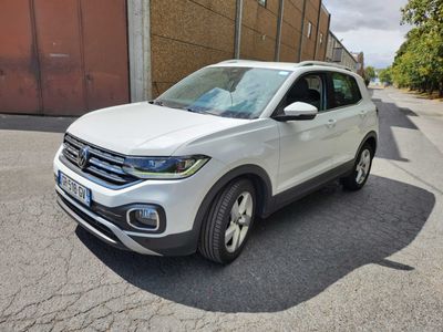 Le SUV Volkswagen blanc est garé sur le bord de la route.