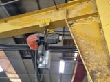 a large yellow crane hanging from the ceiling in a building