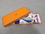 orange box with a pair of socks in it sitting on a gray surface