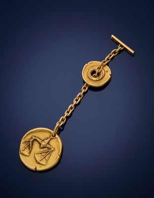 a close up of a gold plated key chain with a coin on it