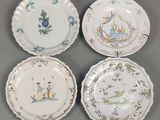 quatre assiettes ornées de motifs différents, posées sur un fond gris