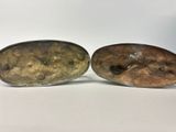 a pair of silver and bronze plated objects on a white surface