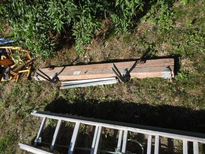 a pile of wood sitting on the ground next to a ladder