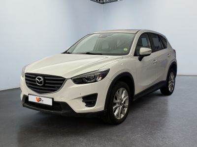 a white mazda cx - 5 parked in a showroom