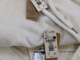 two tags on the hoodie of a white sweatshirt