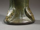 a green vase that has a bird on it