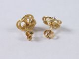 a pair of gold earrings on a white surface