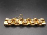 a close up of a gold plated necklace on a black surface