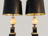 a pair of black and gold table lamps with marble balls
