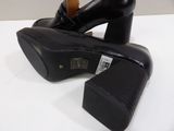 pair of black high heeled shoes sitting on top of a white table