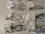 several pairs of eyeglasses are in plastic bags on a table