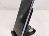 a close up of a cell phone on a stand on a white surface