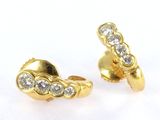 two pairs of gold and diamond earrings on a white surface
