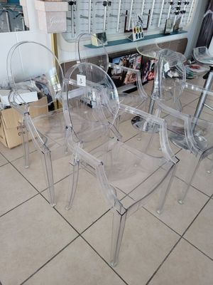 four clear chairs sitting on the floor in a store