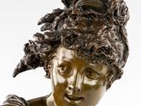 bronze statue of a woman with a hat on her head
