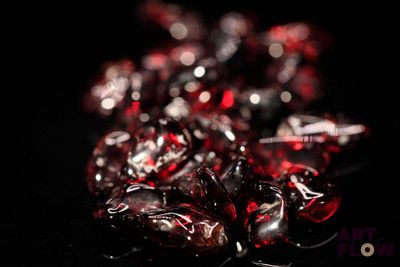 un gros plan sur un groupe de cristaux rouges posés sur une surface noire