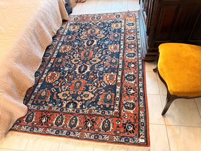 a rug on the floor next to a chair in a bedroom