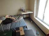 a small bed in a small room with a window