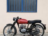 a red motorcycle parked in front of a building with a blue window