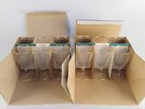 several empty wine glasses in a cardboard box on a white surface