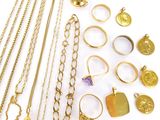 a lot of gold jewelry on a white surface