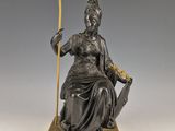 une statue antique en bronze représentant une femme tenant une lance et un bouclier