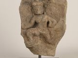 une image représentant une sculpture en pierre d'une femme assise sur un rocher