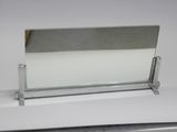 un porte-cartes de visite en verre posé sur une surface blanche