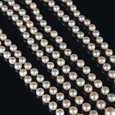 a close up of a strand of pearls on a black surface