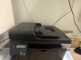 a printer sitting on top of a desk next to a pile of books