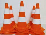 plusieurs cônes de signalisation orange et blancs posés sur une table blanche