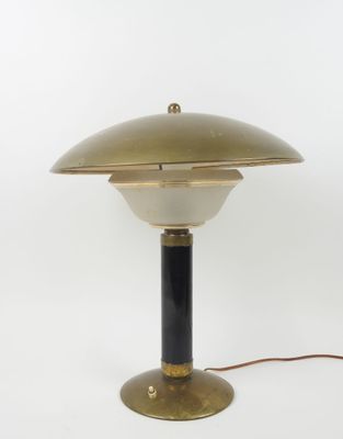 a brass and black table lamp on a white background