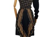 mannequin with a black and gold dress on display on a wooden stand