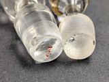 two glass vials with blood on them sitting on a table