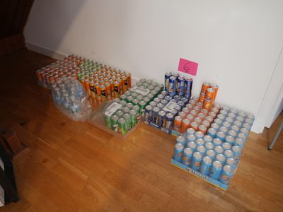 many cans of soda sitting on the floor next to each other